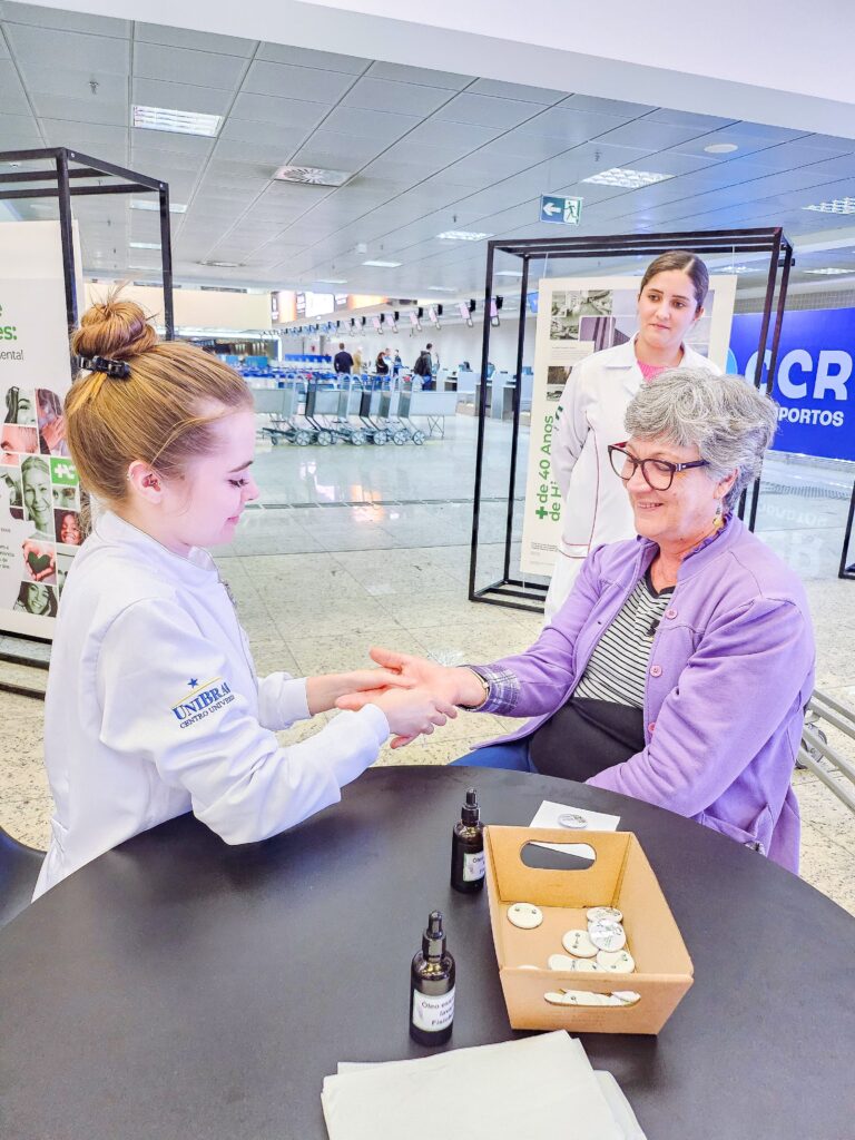 Enfermeira aplicando reflexologia no aeroporto