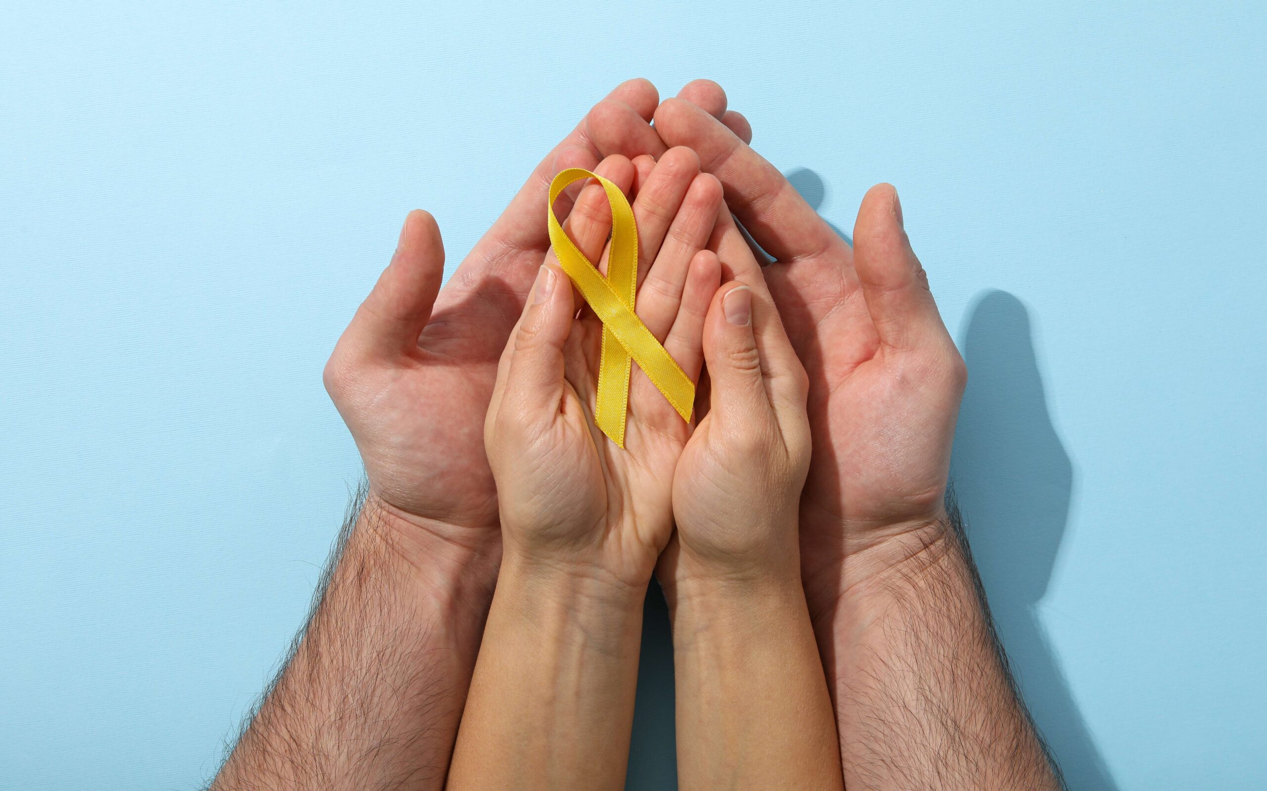 Mãos segurando um laço símbolo do Setembro Amarelo